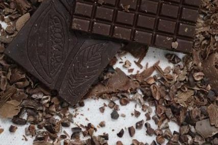 Tableta de chocolate oscuro sobre nibs de cacao